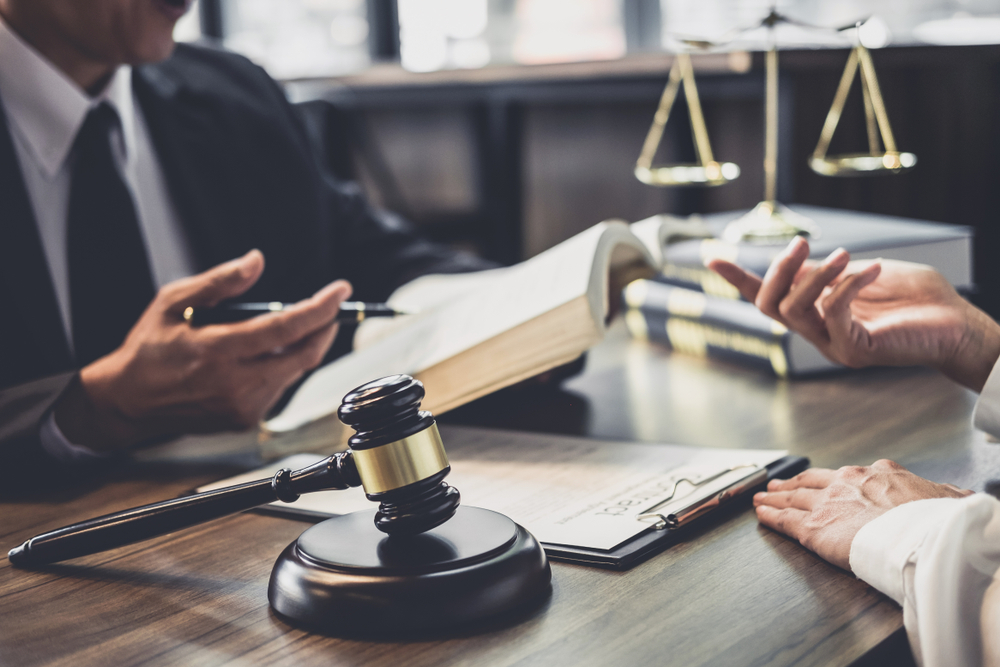 two men discussing settling debts with Discover around papers and a gavel
